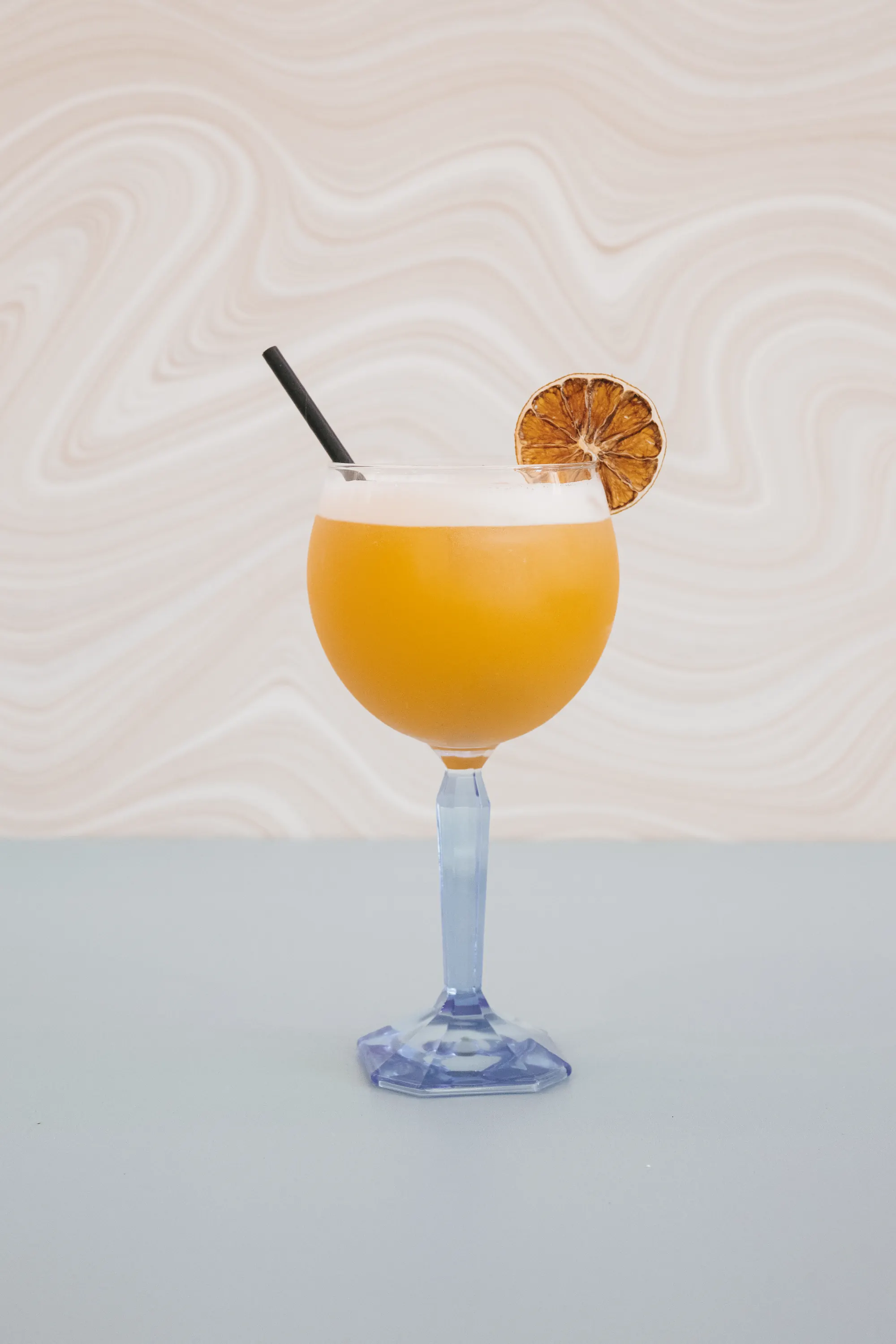 Sweet Gin en verre ballon à pied bleu, rondelle d'agrume séchée